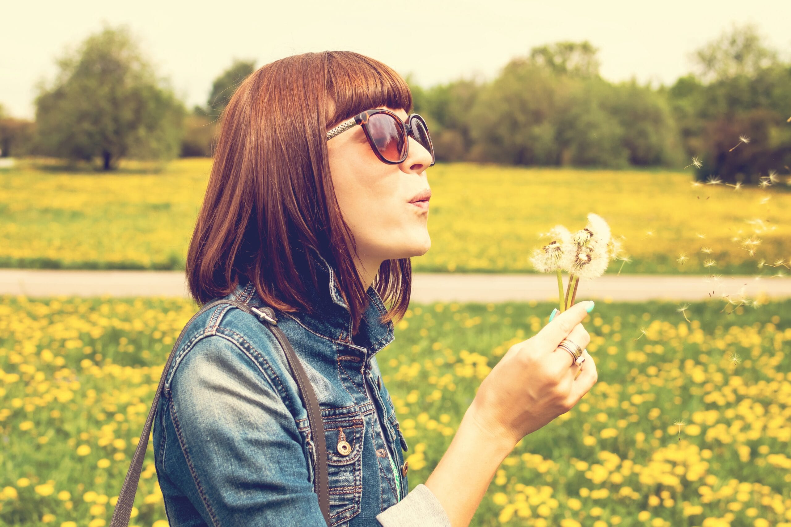 Woman blowing dandellions